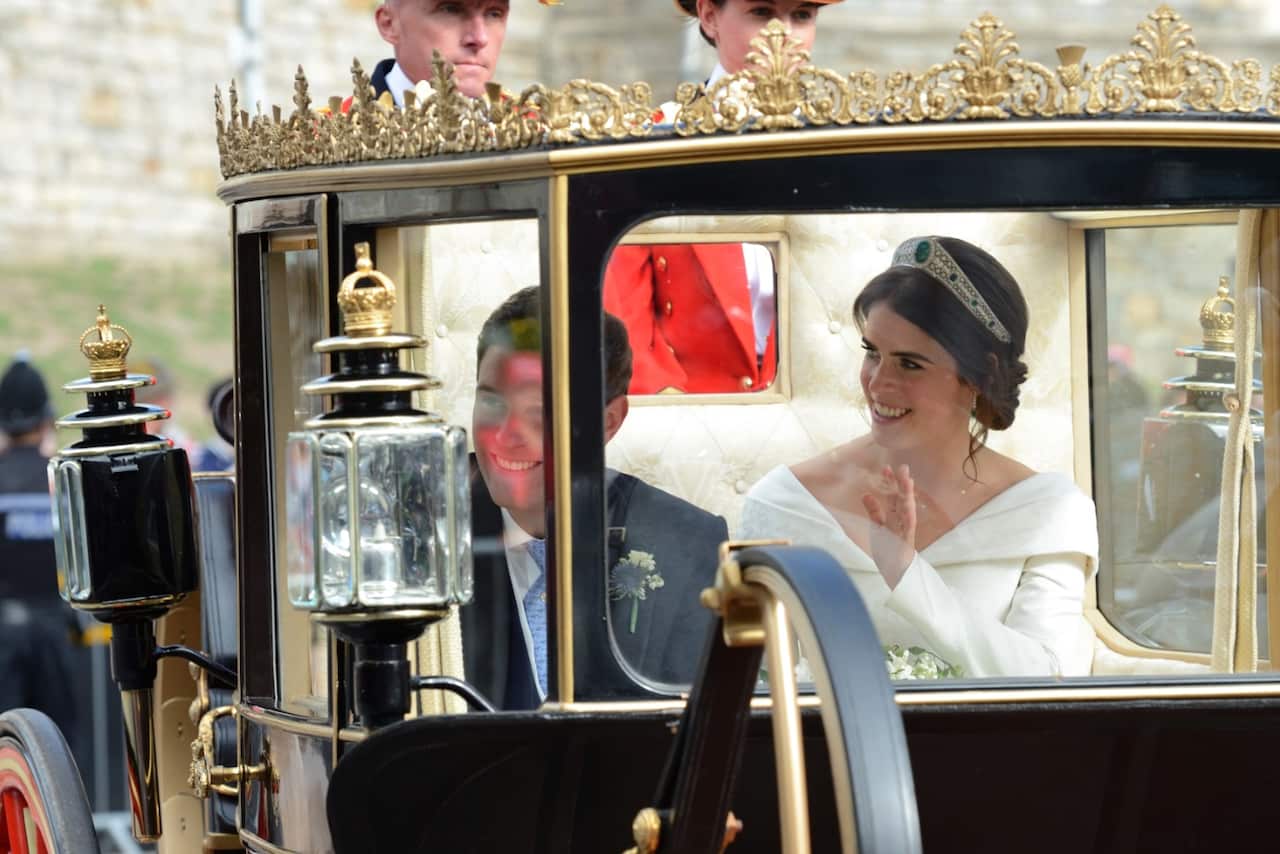 Newlywed Princess Eugenie of York waves to the crowd from her carriage after her Royal wedding to Mr. Jack Brooksbank at St. George's Chapel in Windsor