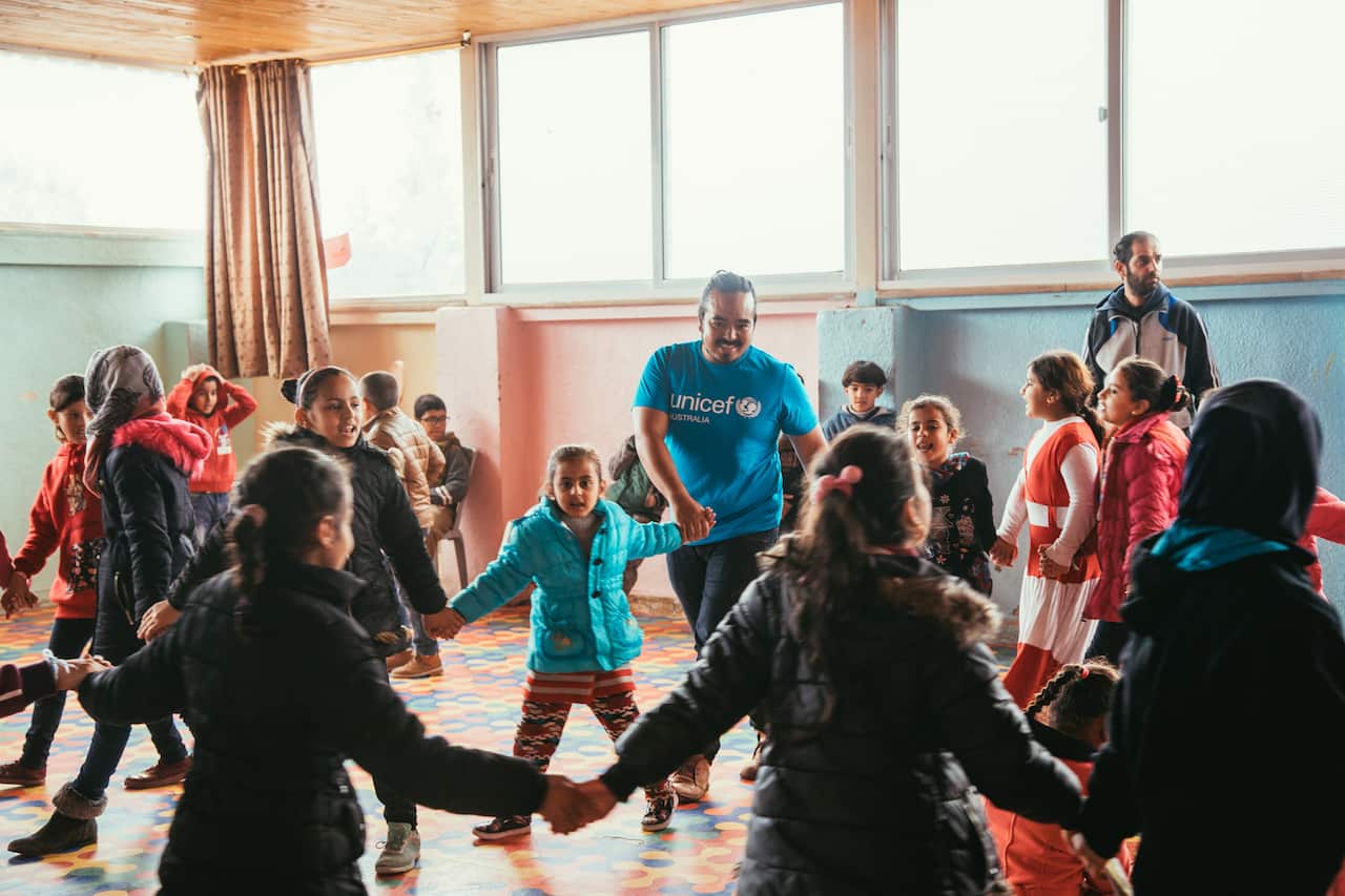 Adam Liaw, centre, dancing with some of the children in the Zaatari camp. 