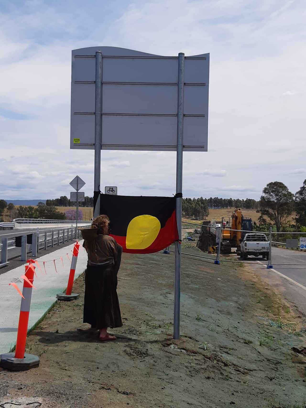 A community member hoists the Aboriginal flag on the site
