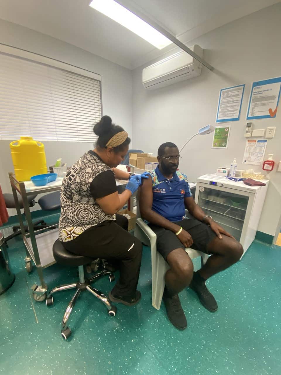 ATSICHS Mackay Registered Nurse Teiraen Toarei administering Covid-19 jab for male health worker Frank Cook.