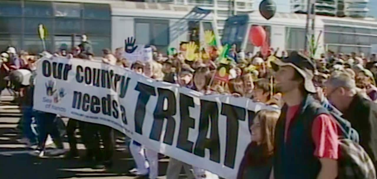 Walkers on the Harbour Bridge hold banner calling for Treaty.