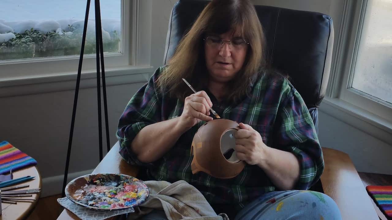 Artist Paula Strawn painting a baby helmet