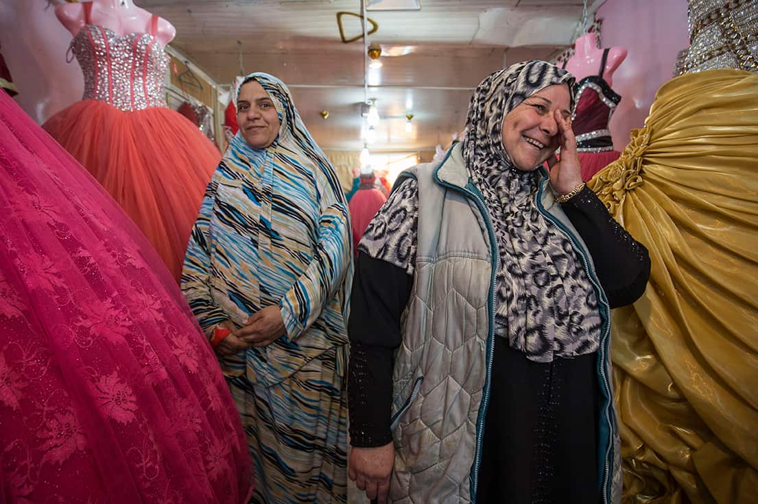 Um Mohamad stands with her trainee Um Ala’a who will run the store for around 10 days when Um Mohamad takes time off to have her fifth child. 