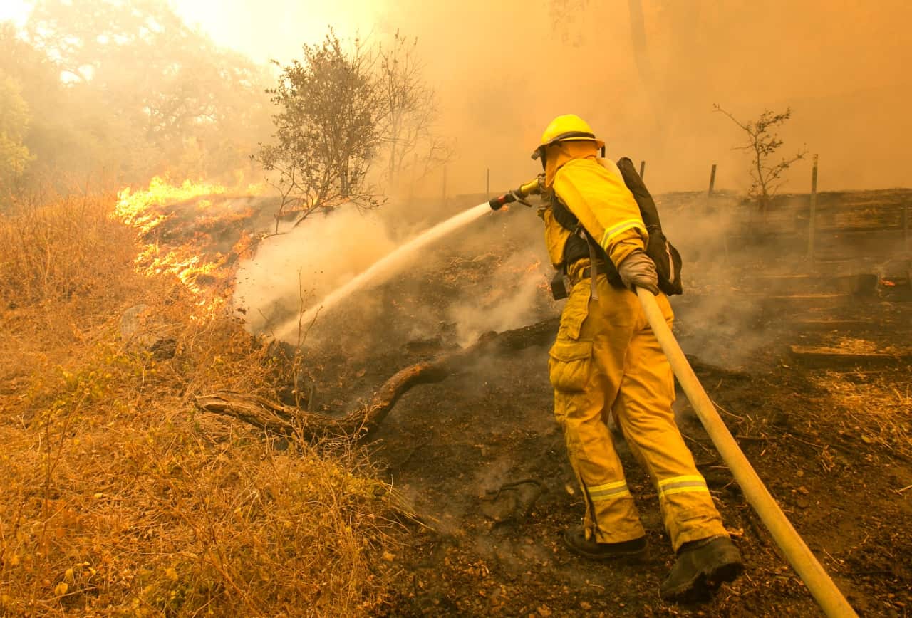Napa County firefighter James George hoses down a fireline approaching a home Monday, Oct. 9, 2017, in Napa, Calif (AAP)