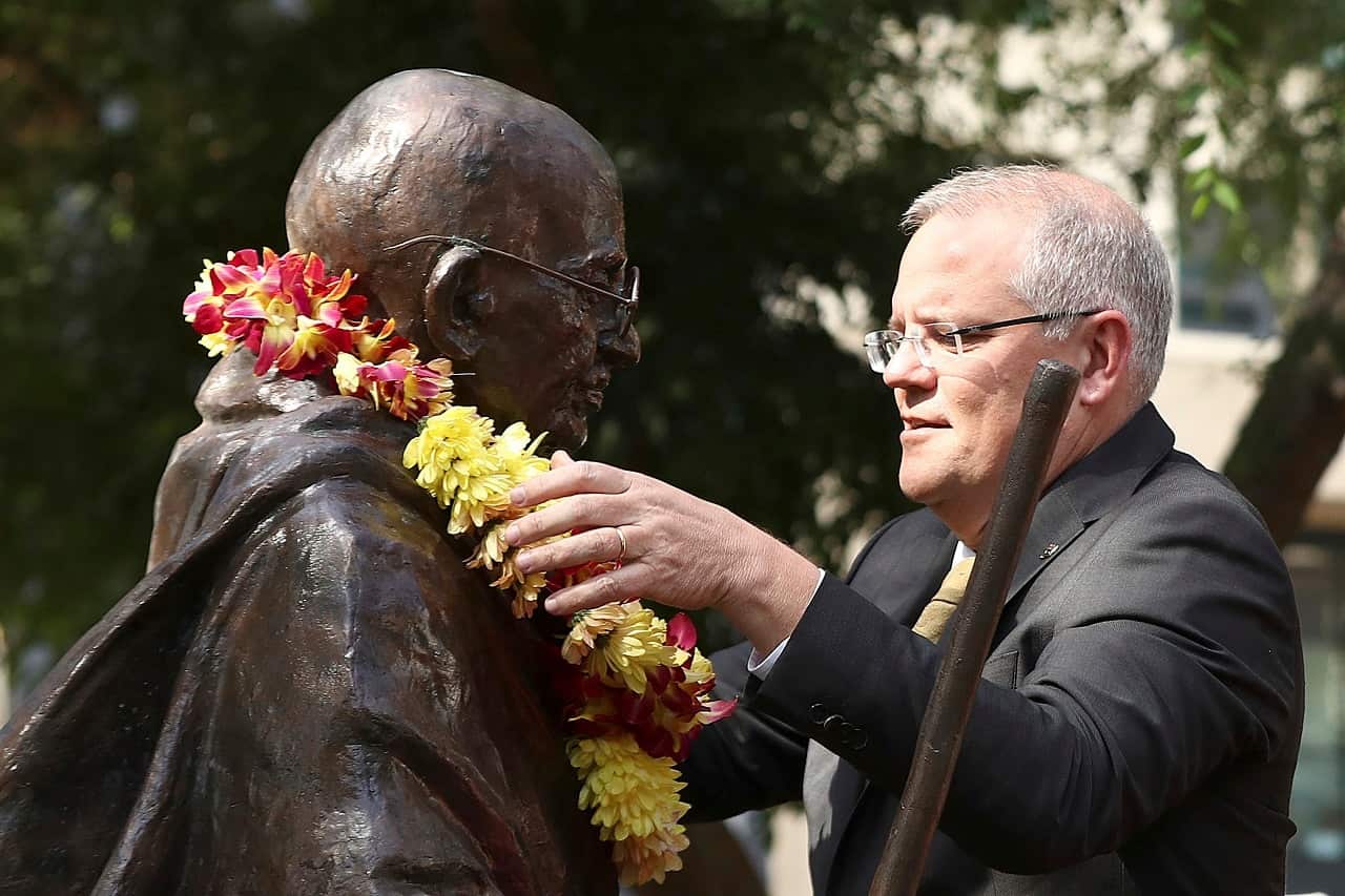 Scott Morrison places flowers on the Gandhi statue.