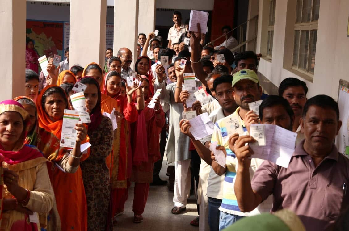 Villager voters show their voter slips as they stand in a queue to cast their votes at a polling station during the seventh and last phase of parliamentary elections, at village Baldhar, about 20km from Dharamsala, India (AAP)