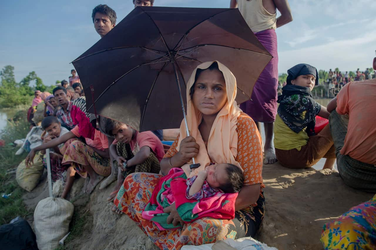 Rohingya Muslim woman Anjuna Khatoon, holds her 5-day-old baby girl who she gave birth to while making the journey across the border from Myanmar to Bangladesh.