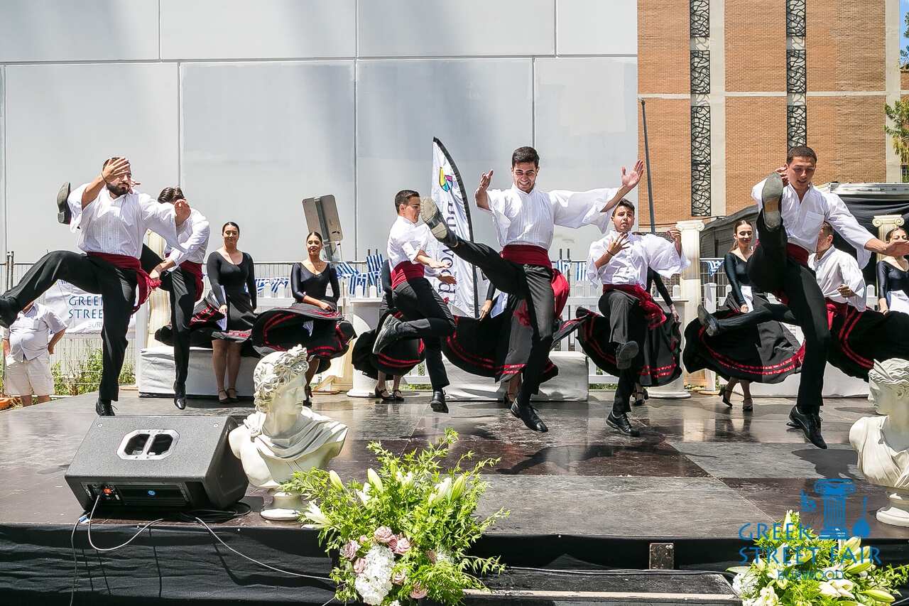 Traditional Greek dancing performance where the males are spaced apart and kick their feet into the air.