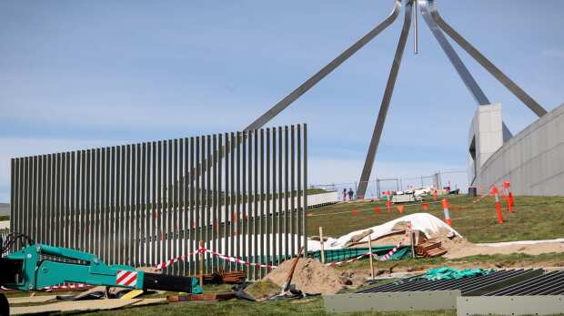 A security fence is installed across the lawns of Parliament House in Canberra.