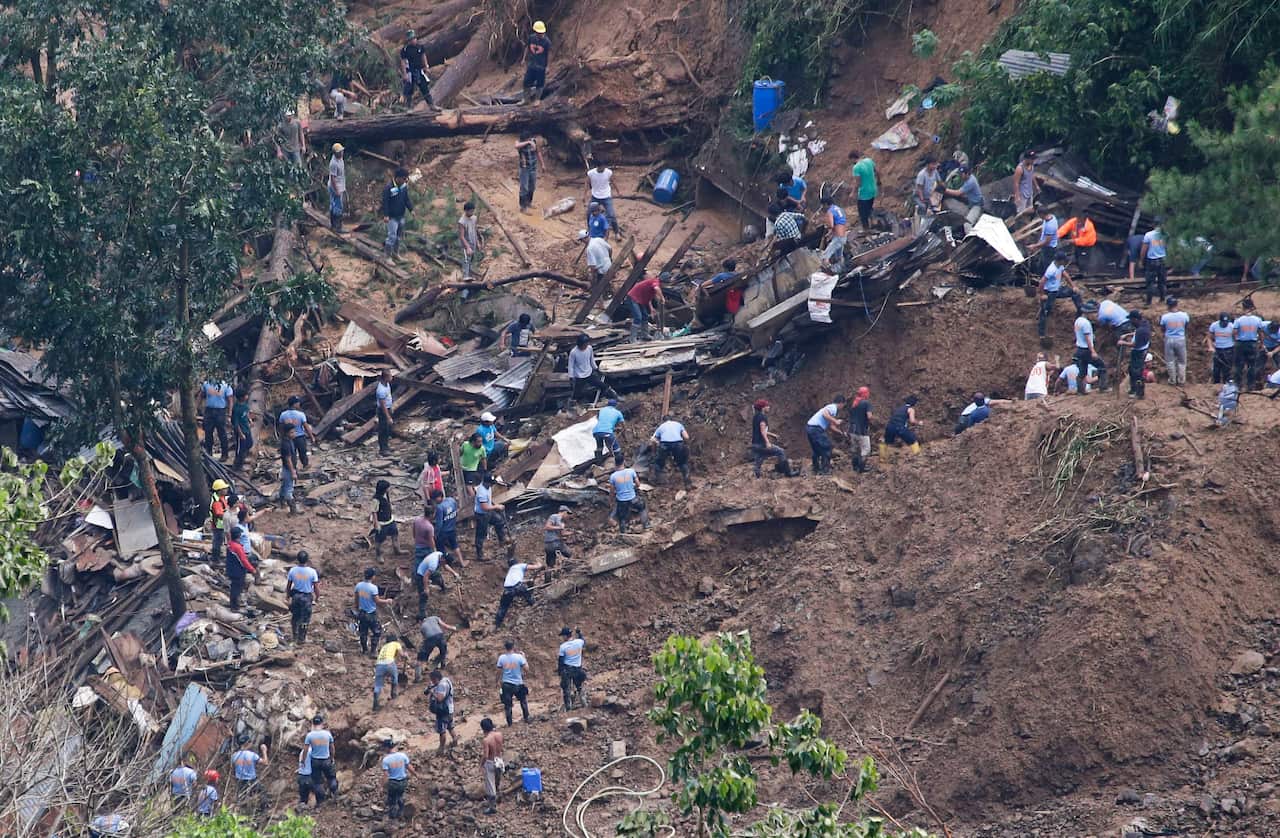 Rescuers work on the site where victims were believed to have been buried by a landslide after Typhoon Mangkhut barreled across Itogon, Benguet province, northern Philippines, Monday, Sept. 17, 2018.