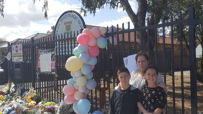 A mother and her children outside the Banksia Road Public School in Greenacre, Sydney