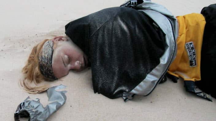 a schoolie sleeps off the first night of life after high school on the beach