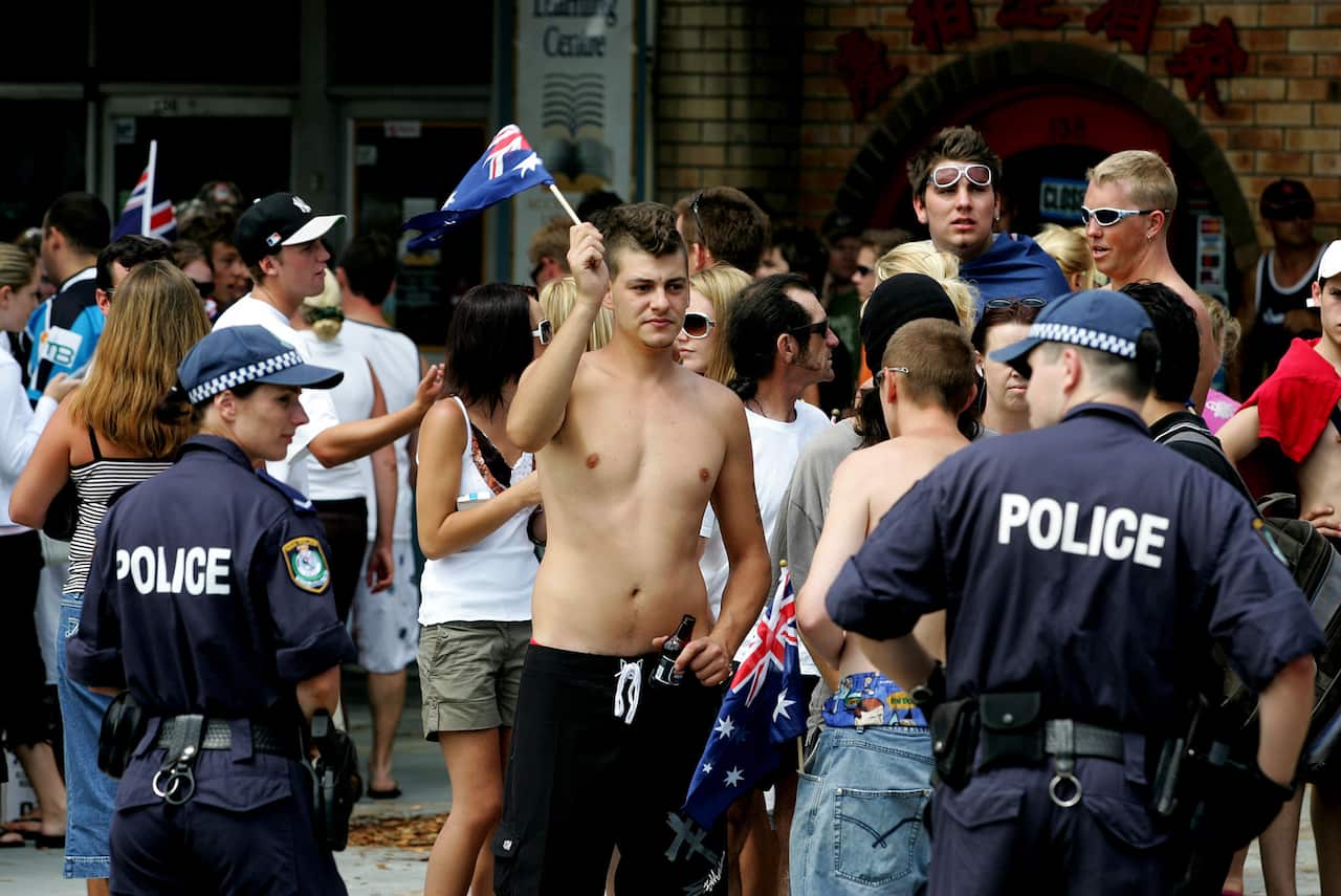 Police form a line to hold back the crowd at Cronulla railway station in Sydney, Sunday