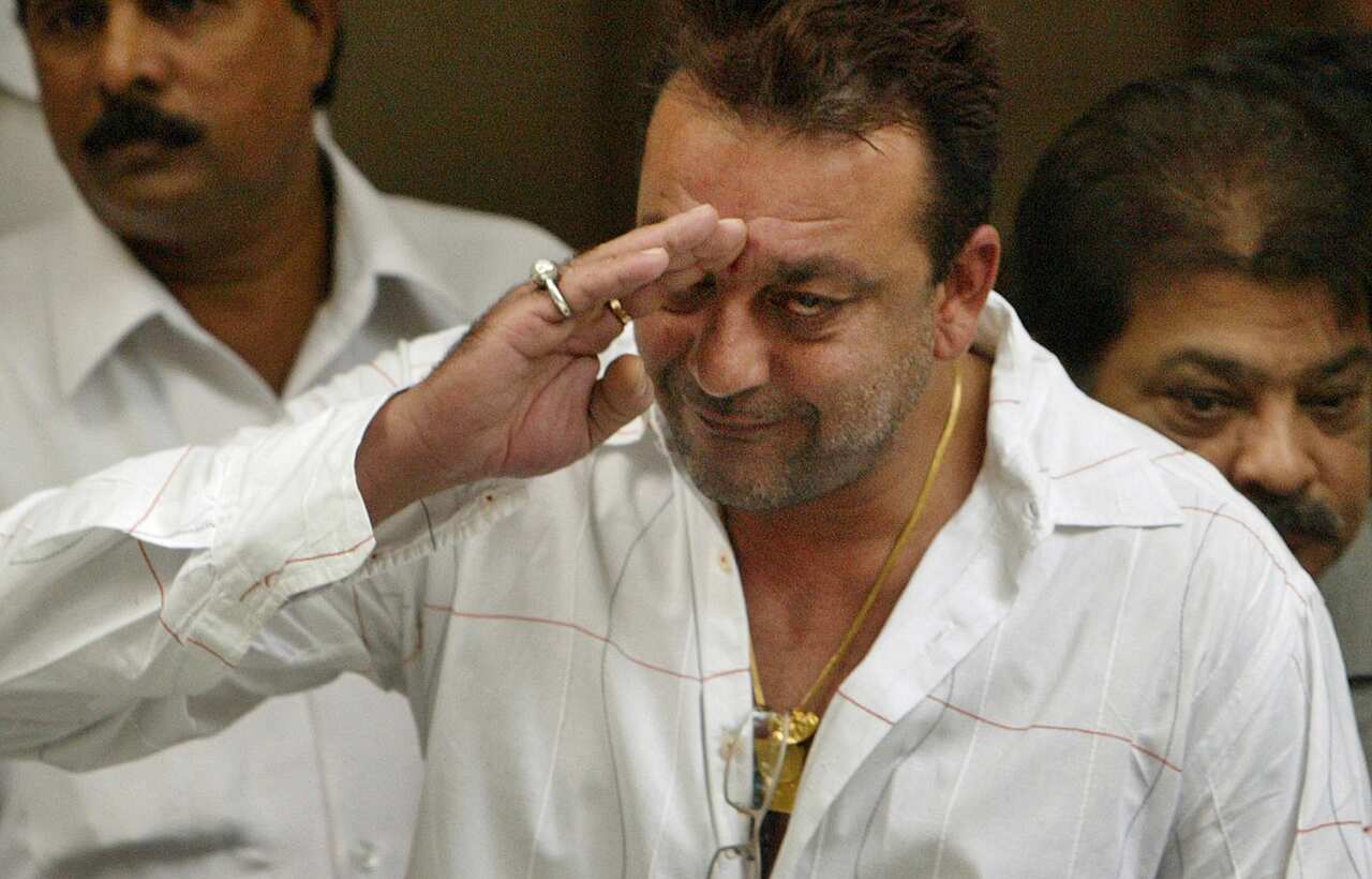Sanjay Dutt acknowledges photographers before leaving his residence for the special court trying cases of the 1993 Mumbai bombings in July 2007.