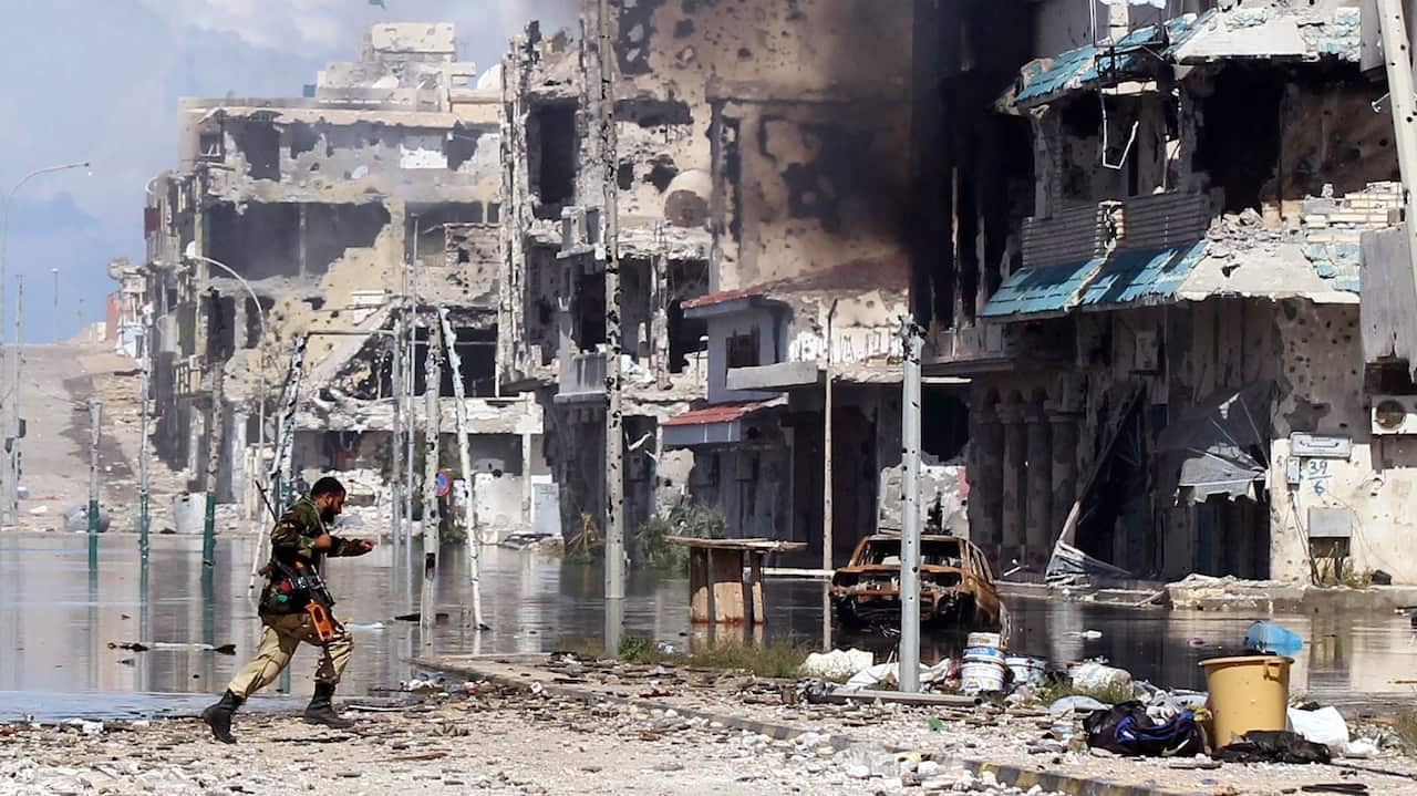 Libyan rebel fighter runs to take cover from incoming sniper's fire during the battle in the city of Sirte, Libya, 14 October 2011. 