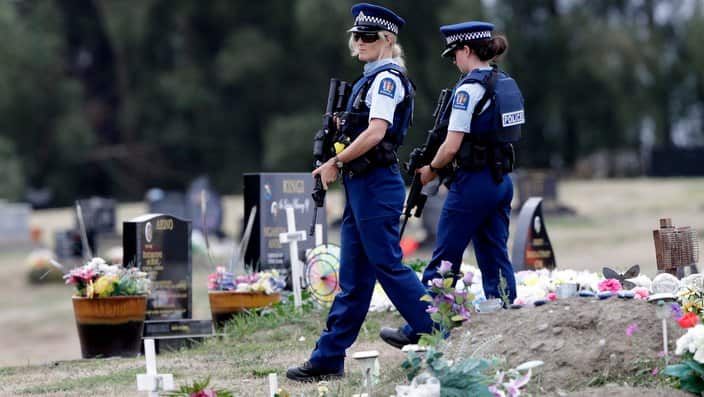 Armed police patrol a cemetery near Muslim graves in Christchurch, New Zealand.
