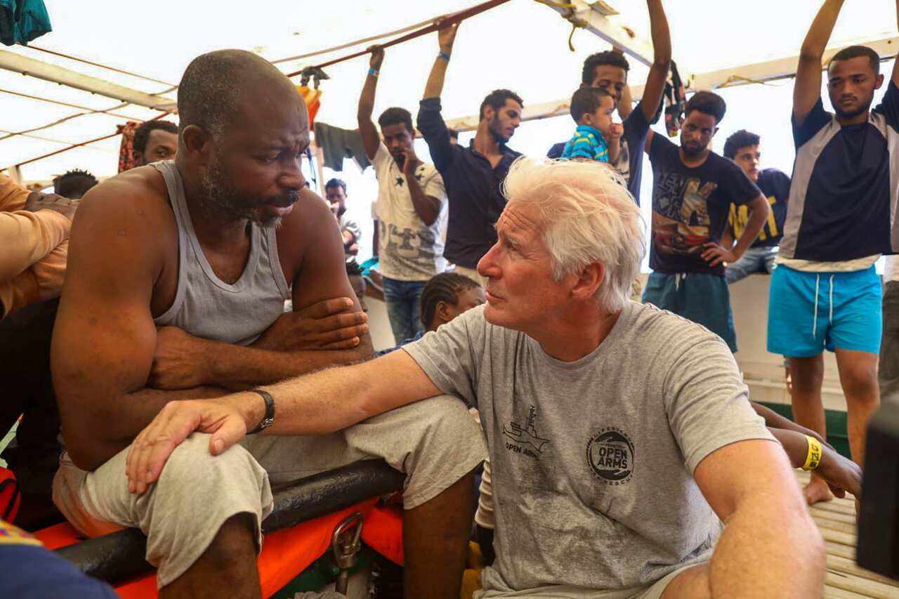 Richard Gere parla con un migrante a bordo della Open Arms 