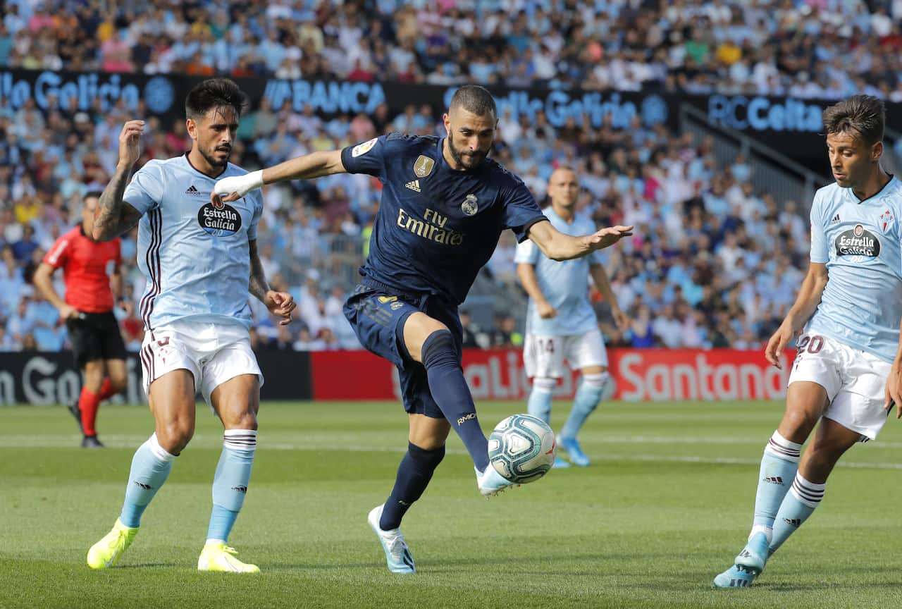epa07778125 Real Madrid's French forward Karim Benzema (C) vies the ball against Celta Vigo's David Costas (L) and Kevin Vazquez (R) during their LaLiga game at Balaidos Stadium, in Vigo, northwestern Spain, 17 August 2019.  EPA/Lavandeira Jr