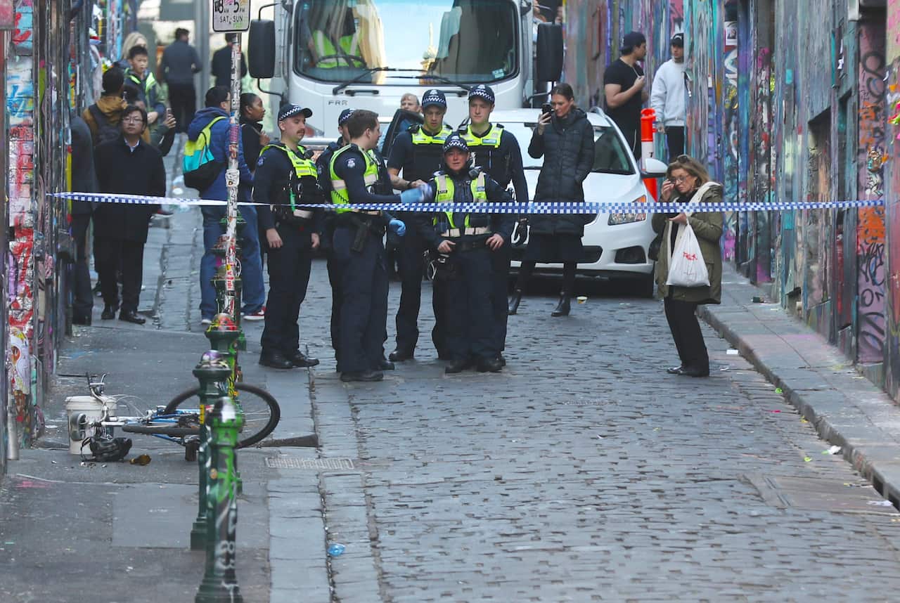 Police inspect the scene where fugitive Jonathan Dick has been arrested in Hosier Lane, Melbourne.