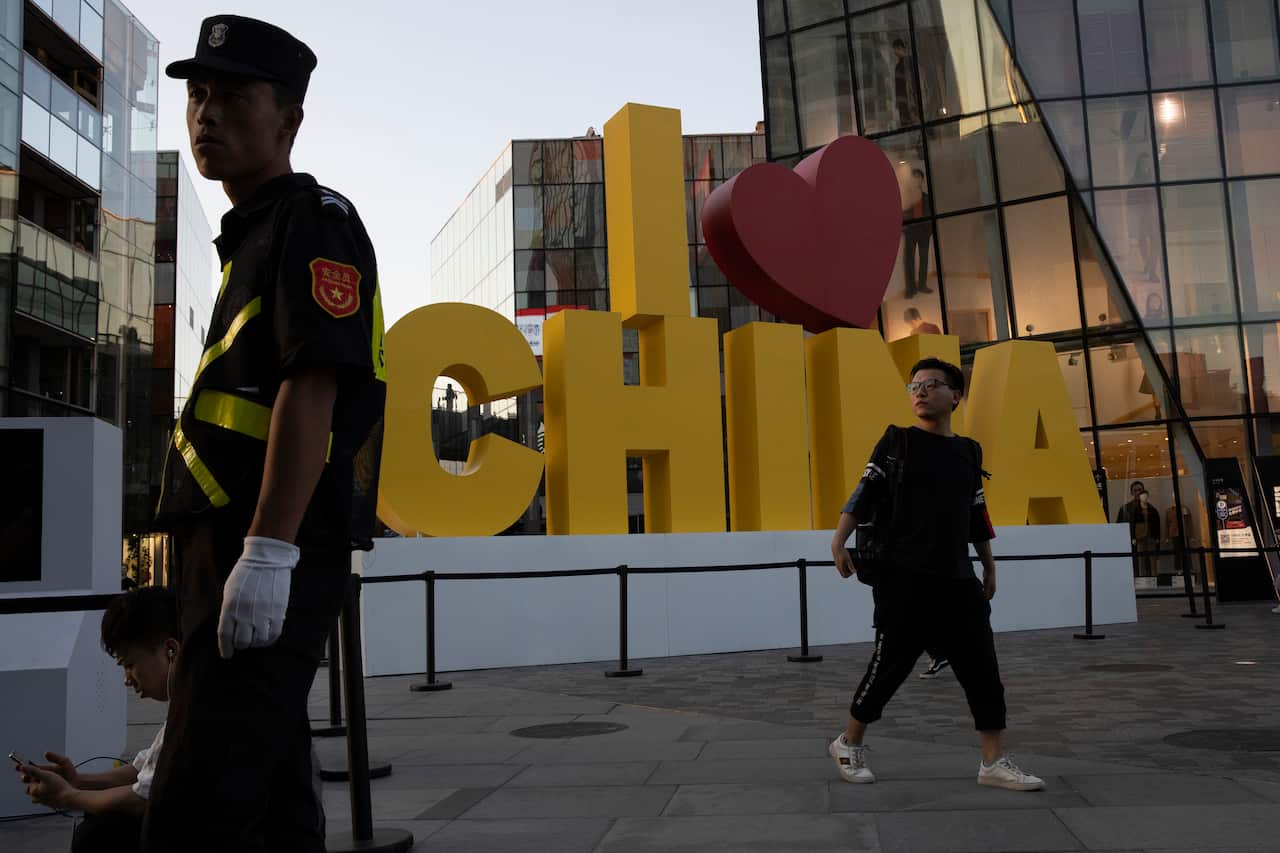 HOLD FOR STORY CHINA 70 YEARS PHOTO GALLERY In this photo taken Monday, Sept. 23, 2019, a man walks past a "I love China" decoration with a red heart shape at a trendy retail district in Beijing. Patriotic banners, elaborate flower displays and tightened 