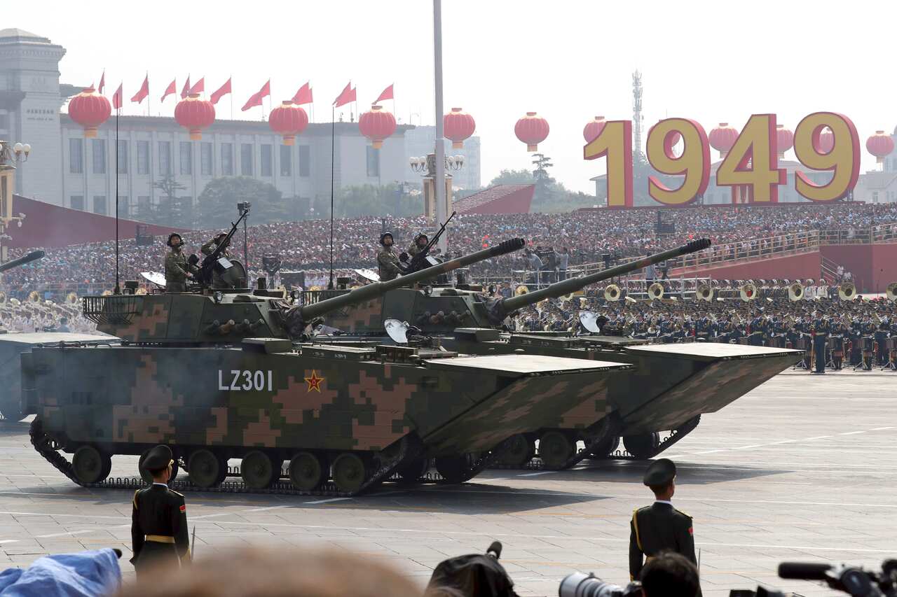 Military vehicles roll down as members of a Chinese military honor guard march during the parade to commemorate the 70th anniversary of the founding of Communist China in Beijing, Tuesday, Oct. 1, 2019. (AP Photo/Ng Han Guan)