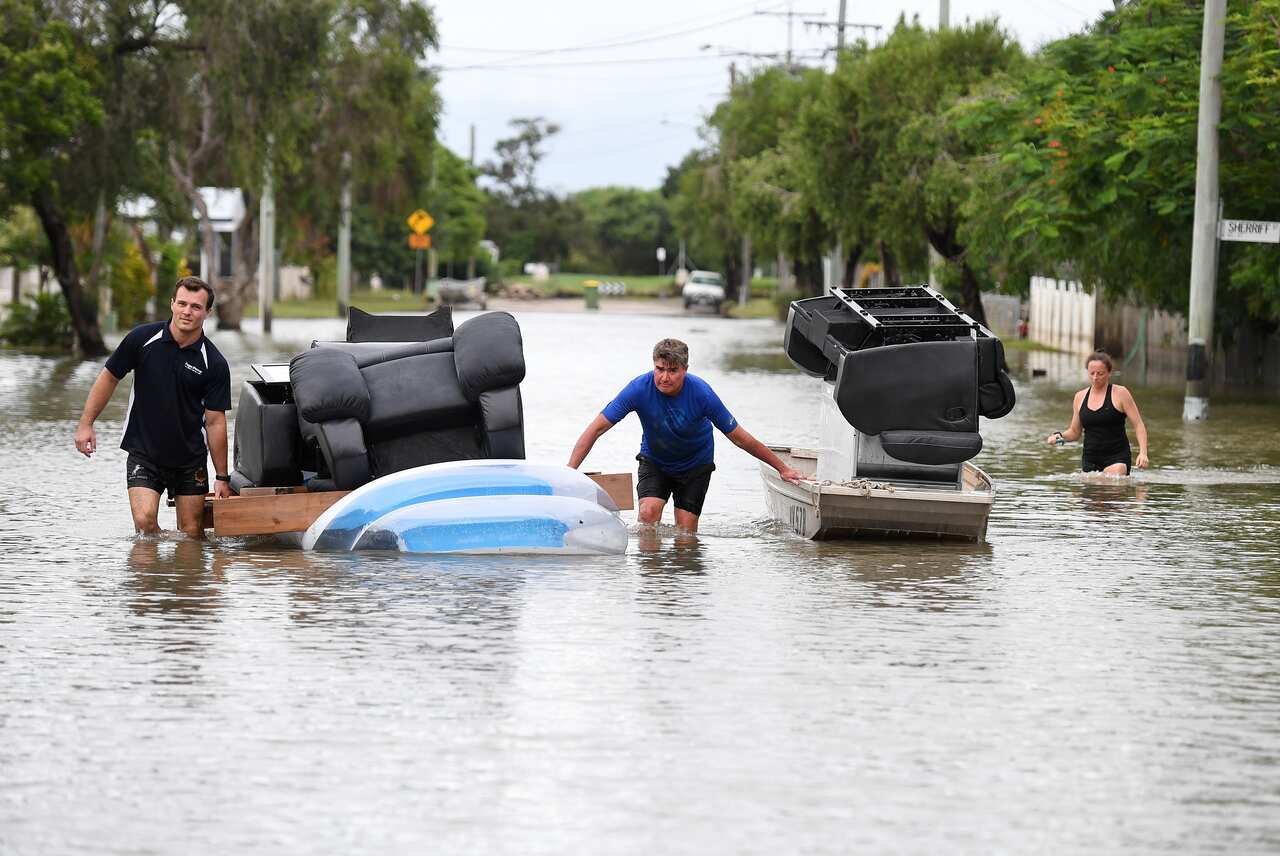 Local residents use a boat and an inflatable pool to salvage furniture from their flood-affected home in Townsville, Wednesday, February 6, 2019.