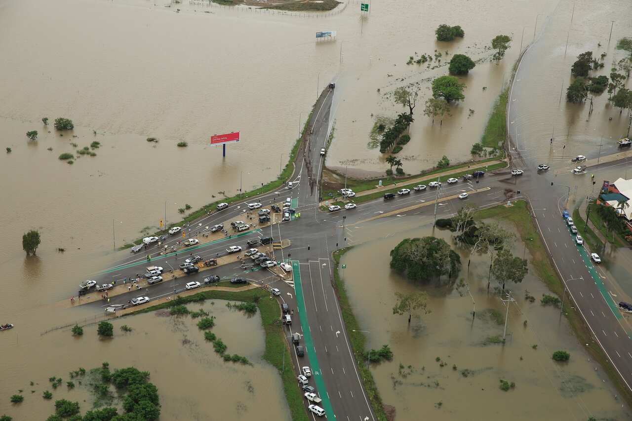 Stranded vehicles are seen from above as floodwater engulfs the intersection of Stuart Drive and the Bruce Highway in Townsville, February 4