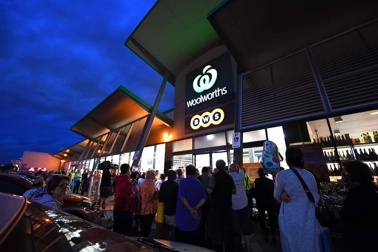 People are seen waiting outside a Woolworths supermarket in Coburg, Melbourne, Thursday, 