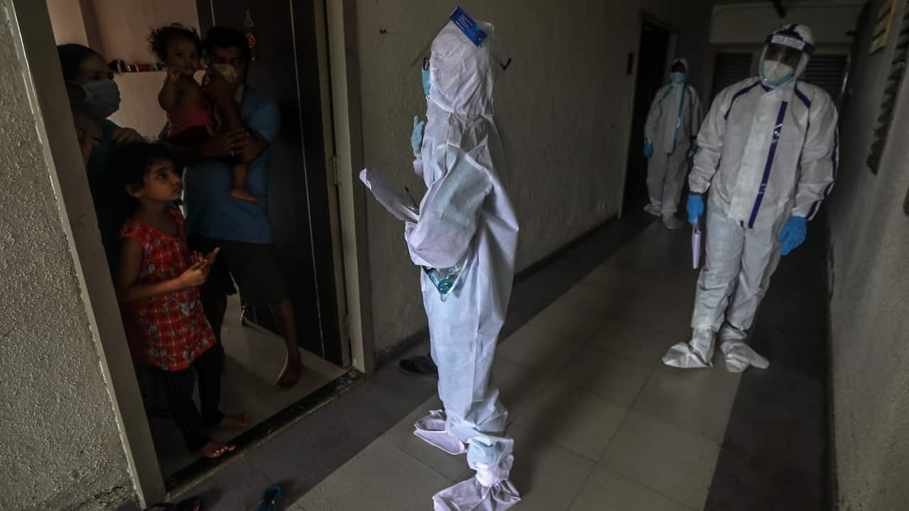 An Indian health worker wearing personal protective equipment (PPE) counsels the residents of a 'containment zones' after conducting the health check up, in Mumbai, India,