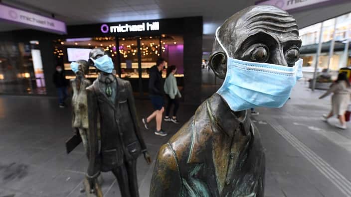 Masks are seen on a statue along Swanston street in Melbourn