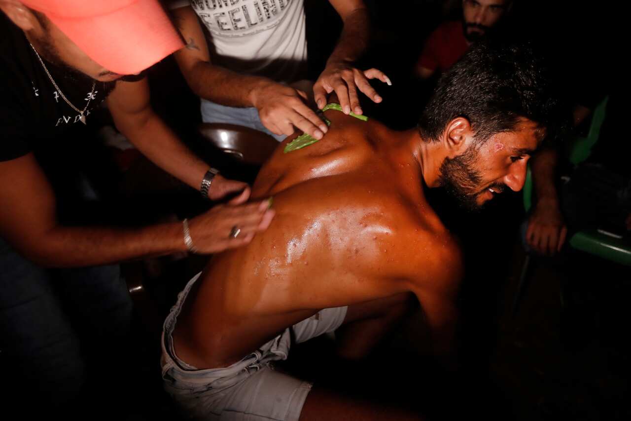 Lebanese Ibrahim Lasheen, 22, who was brought back to his hometown after a U.N. naval force rescued him after he swam for 18 hours while he was migrating on a boat to Cyprus, as he received herbs treatments by his friends at his house, in Tripoli, north L