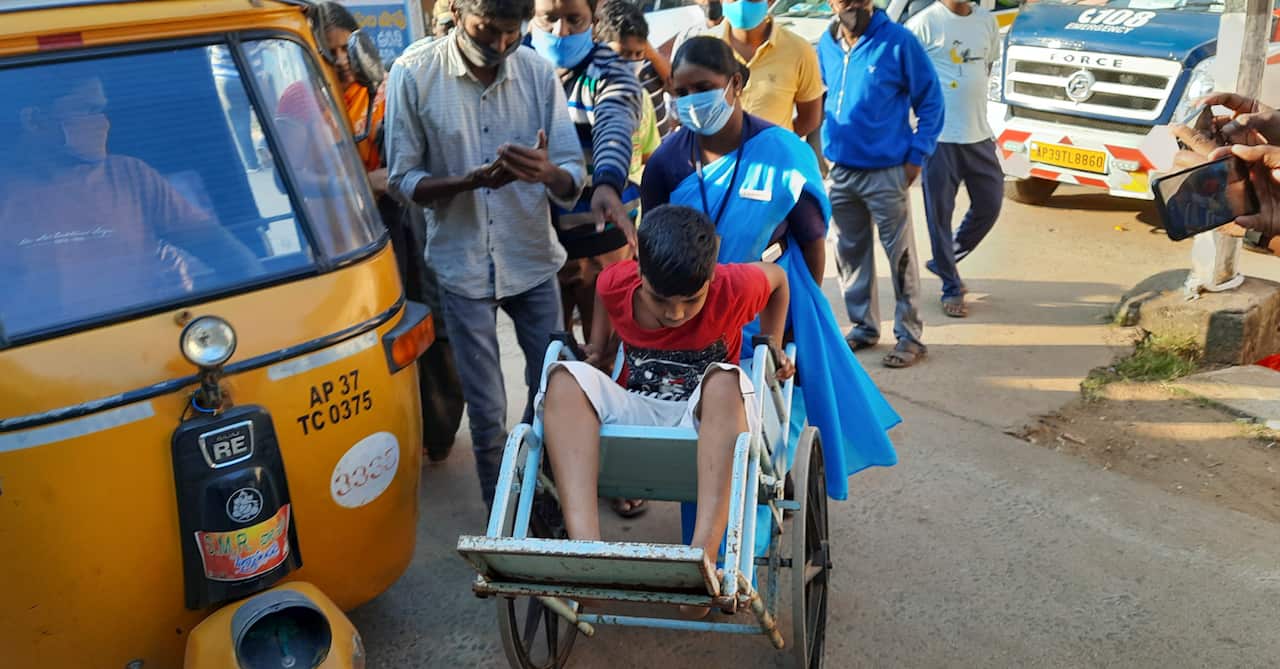 A young patient is brought in a wheelchair to the district government hospital in Eluru, Andhra Pradesh state, India