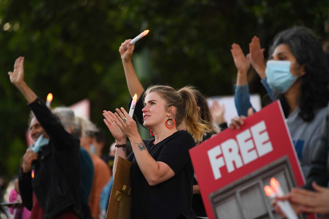 People are seen during a candlelight vigil outside of the Mantra Hotel in Preston, Melbourne, Thursday, December 10, 2020. 