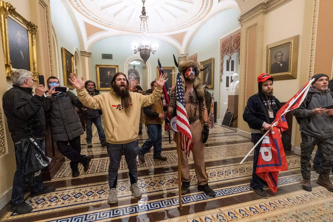 Supporter of President Donald Trump are confronted by Capitol Police officers outside the Senate Chamber inside the Capitol