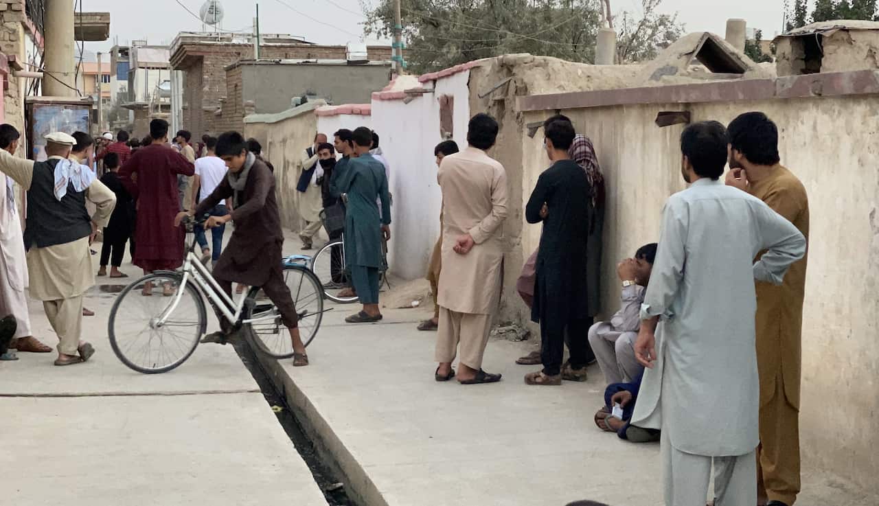 People gather at the scene of a rocket attack near the Hamid Karzai International airport, in Kabul, Afghanistan, 29 August 2021.