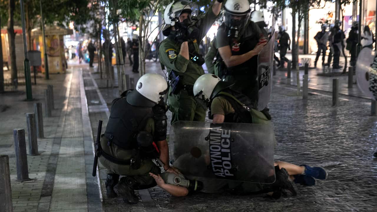 Police detain a masked anti-vaccine protester during clashes around central Syntagma square, in Athens, Greece, Sunday, Aug. 29, 2021. Police used tear gas to disperse thousands of protesters opposing government's plans for mandatory vaccination and new t