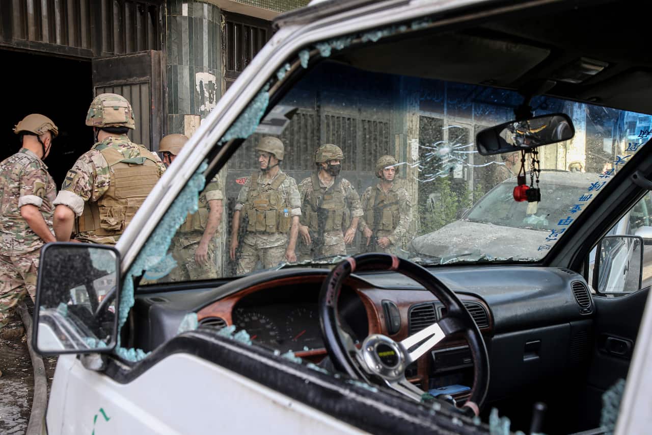 Lebanese military forces are seen through the smashed glass of a vehicle after they were deployed in the area of clashes in the Tayouneh neighborhood