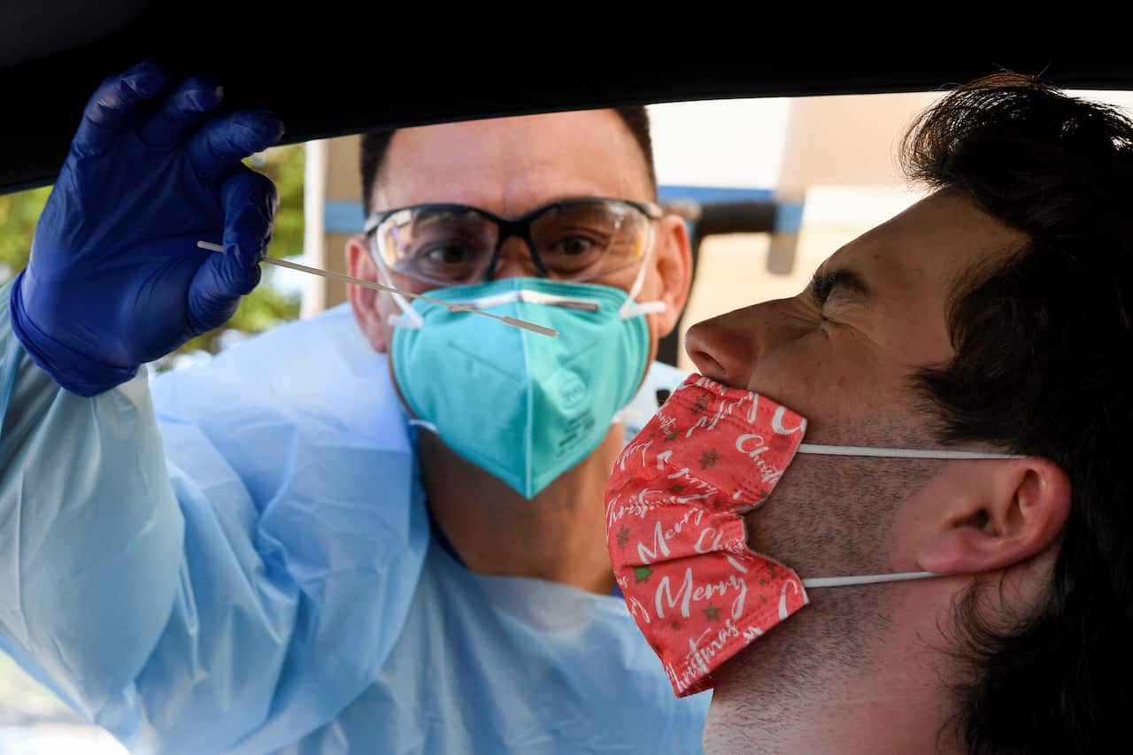 Angus Horton receives a COVID-19 test at the St Vincents Hospital drive-through testing clinic at Bondi Beach in Sydney, Wednesday, December 15, 2021. NSW will open up to the unvaccinated just as COVID-19 cases start to spiral, and the highly transmissibl