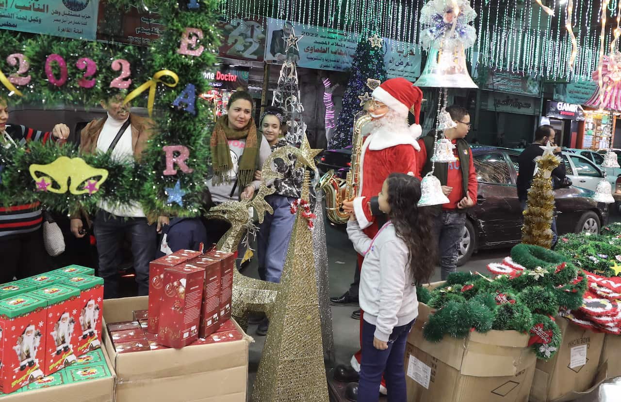 People look at boxes with Christmas holiday and New Year decorations for sale at a market in the Shobra district.