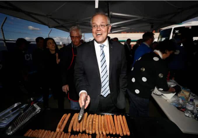 Scott Morrison cooks sausages during a Liberal party campaign rally at Launceston Airport in April 2019 in Launceston