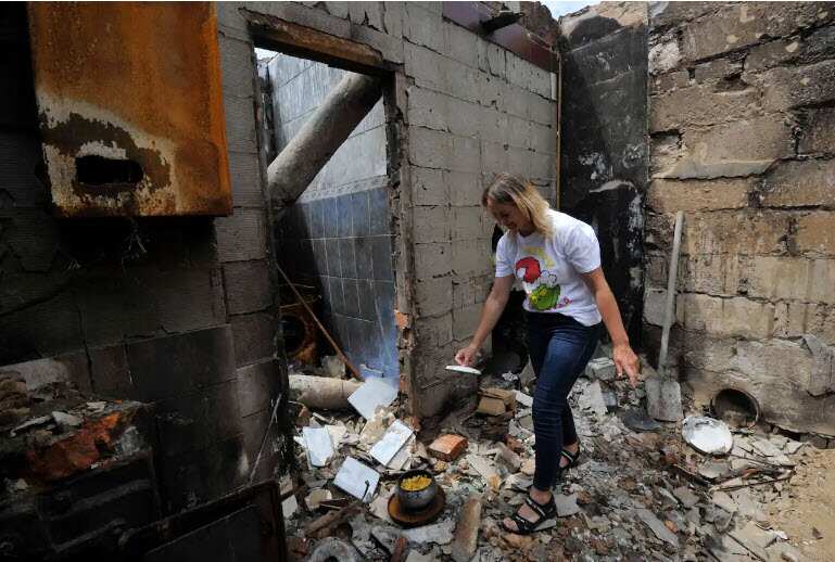 Irina, 35, cooks cottage cheese in the survived wood stove of her ruined house in the village of Novoselivka, outside Chernigiv in Ukraine