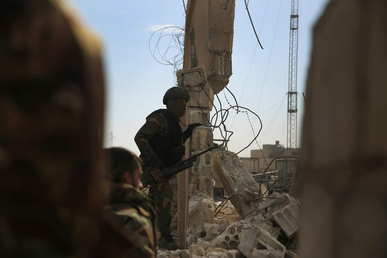 Kurdish-led Syrian Democratic Forces fighters, take their positions at the defense wall of Gweiran Prison, in Hassakeh, northeast Syria, Sunday, Jan. 23, 2022. Clashes between U.S.-backed Syrian Kurdish fighters and militants continued for a fourth day Su