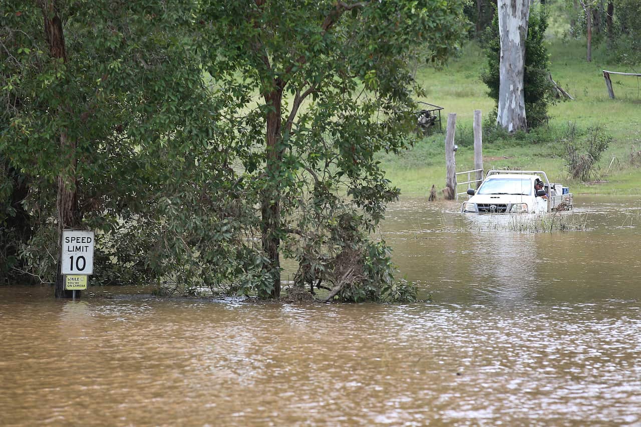 A car attempts to leave their flooded property but turns around near Belli Creek, on the Sunshine Coast, Queensland, Wednesday, February 23, 2022. The body of a 60-year-old has been found in a submerged car in a creek on Queensland's Sunshine Coast after