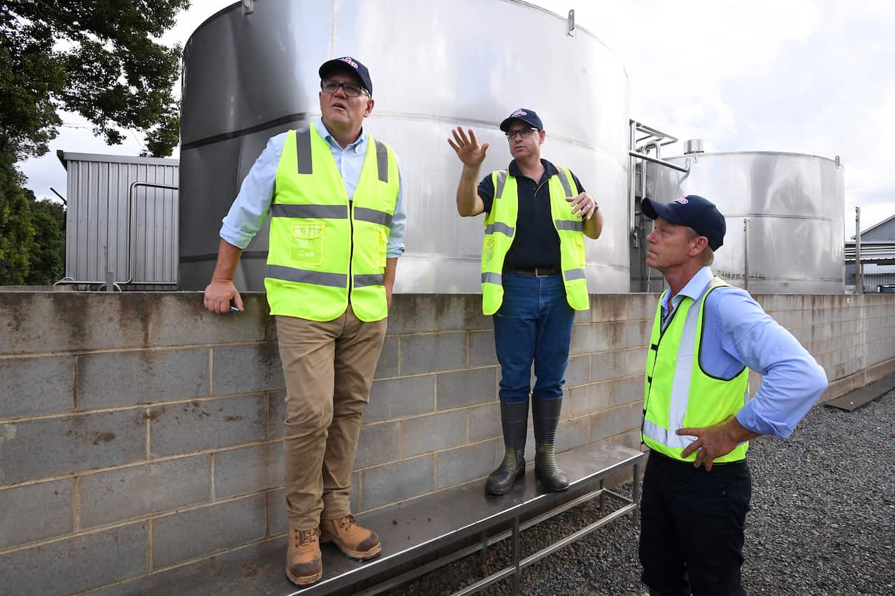 Prime Minister Scott Morrison (left) is given a tour of the Norco Ice Cream Factory by CEO Michael Hampson (centre) and Chairman Mike Jeffery (right) in Lismore, NSW, Wednesday, March 9, 2022. . Prime Minister Scott Morrison has visited flood devastated r