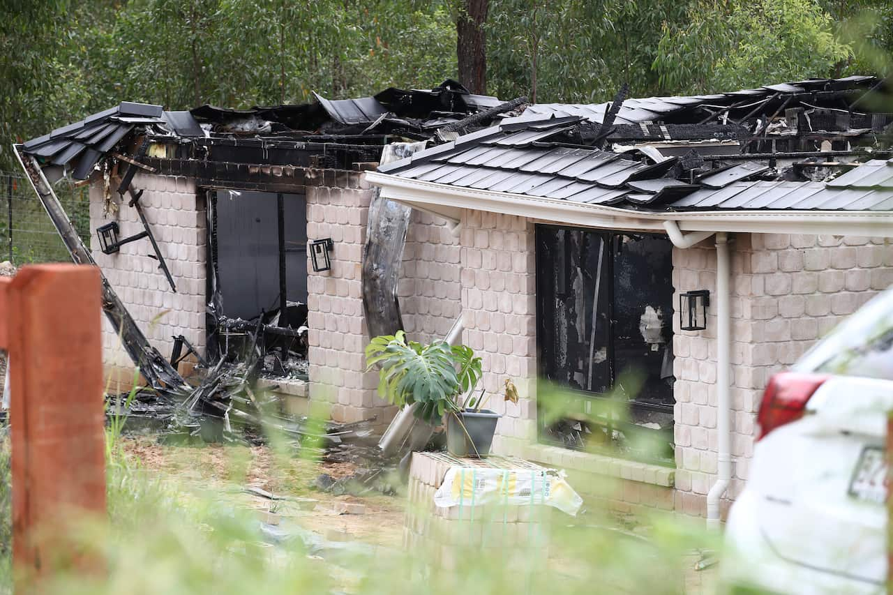 The scene of a fatal house fire near Logan, south of Brisbane, Friday, March 11, 2022. Petrol was involved in the fatal house fire that started after a woman gained entry to the home of a couple south of Brisbane, police say (AAP Image/Jono Searle) NO ARC