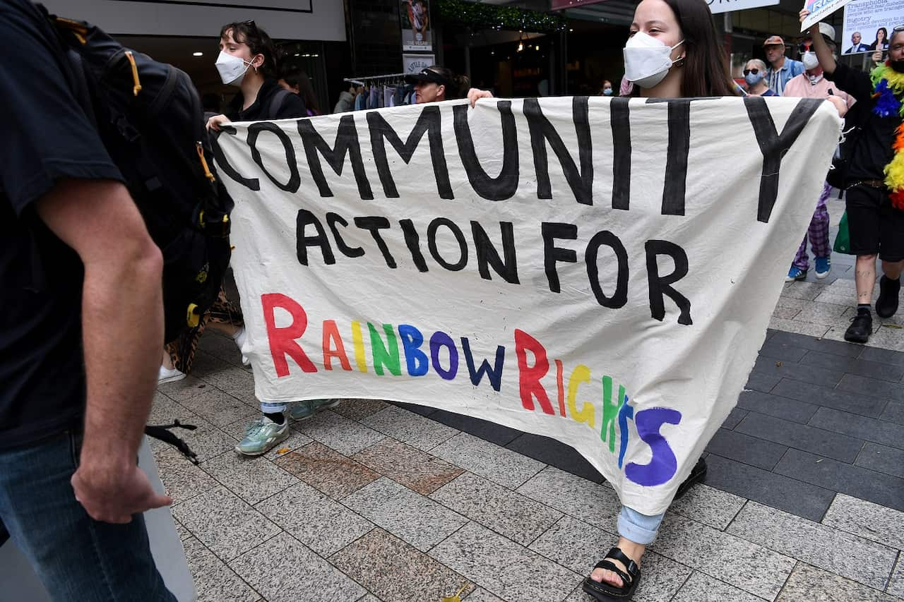 Members of Community Action for Rainbow Rights hold placards as they participate in a protest against candidate for Warringah Katherine Deves at the Manly Corso in Sydney.