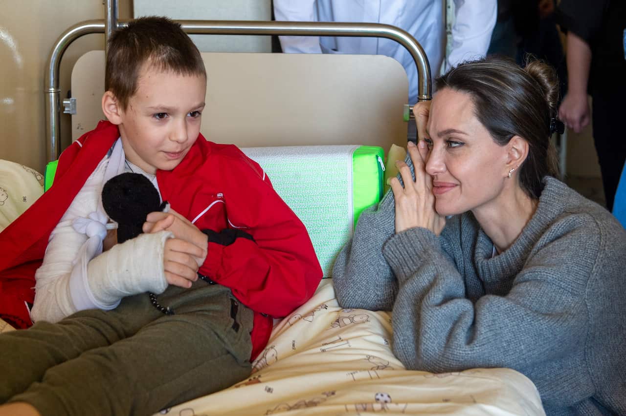 epa09921479 US Actress and UN Goodwill Ambassador Angelina Jolie comforts a young victim of the Kramatorsk railway station missile strike in Lviv children's hospital, in Western Ukraine, 30 April 2022 (issued 01 May 2022).Actress and UN Goodwill Ambassado