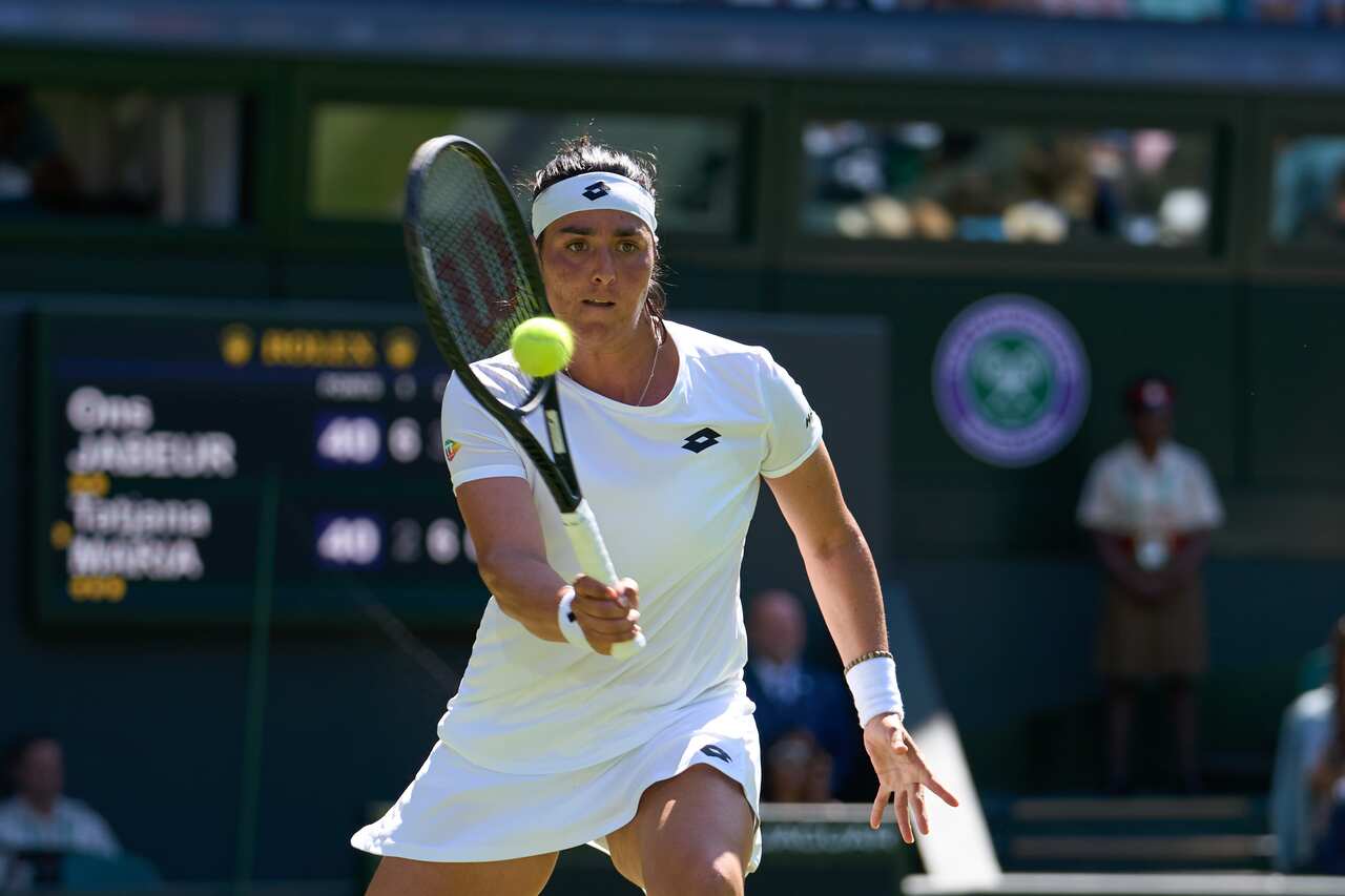 Jul 7, 2022, London, England, United Kingdom,  Ons Jabeur (TUN) returns a shot during  her semi-finals womens singles match against Tatjana Maria (GER) on Centre court at All England Lawn Tennis and Croquet Club. Mandatory Credit: Peter van den Berg-USA T