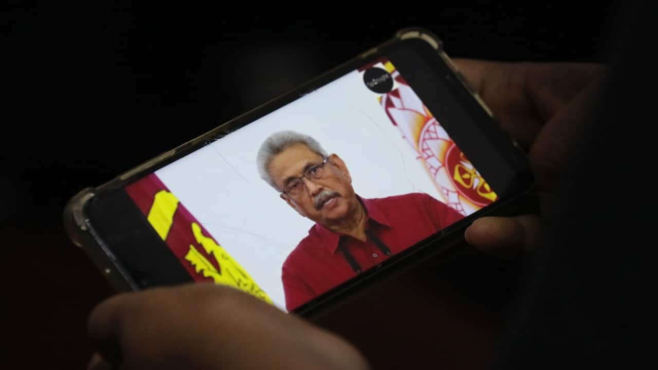 A person watches a video on a mobile phone of Sri Lanka President Gotabaya Rajapaksa addressing the nation on television, in Colombo, Sri Lanka, 11 May 2022