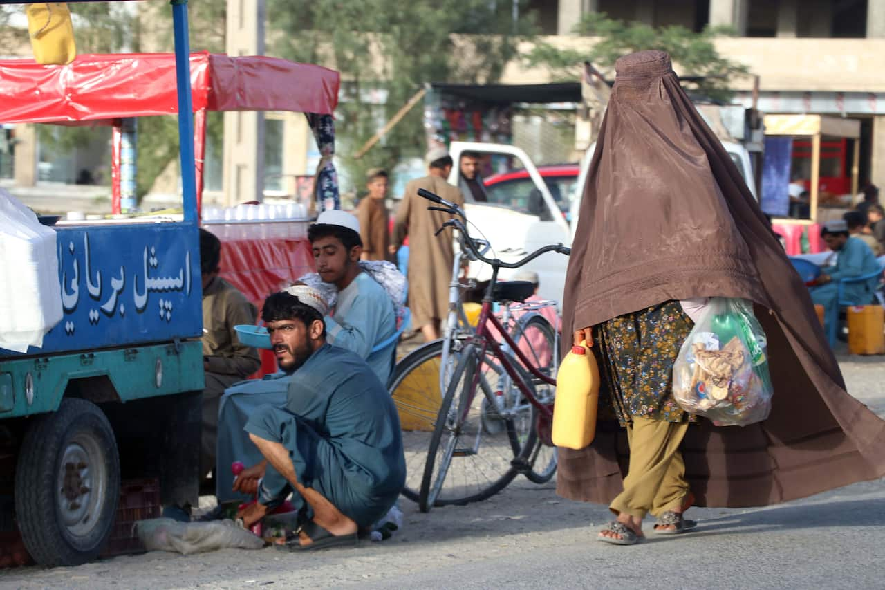 A burqa-clad Afghan woman on a roadside in Kandahar, Afghanistan, 20 July 2022.   